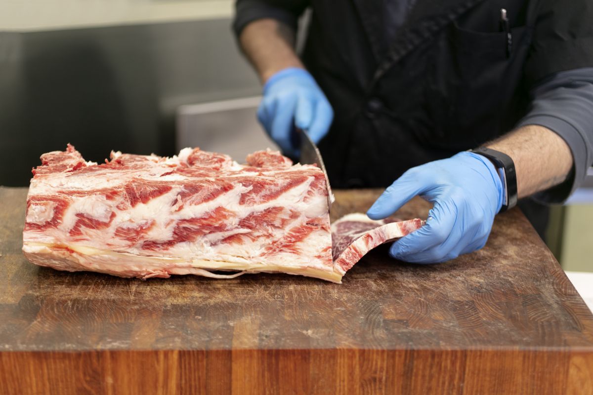 macellaio taglia un pezzo di carne